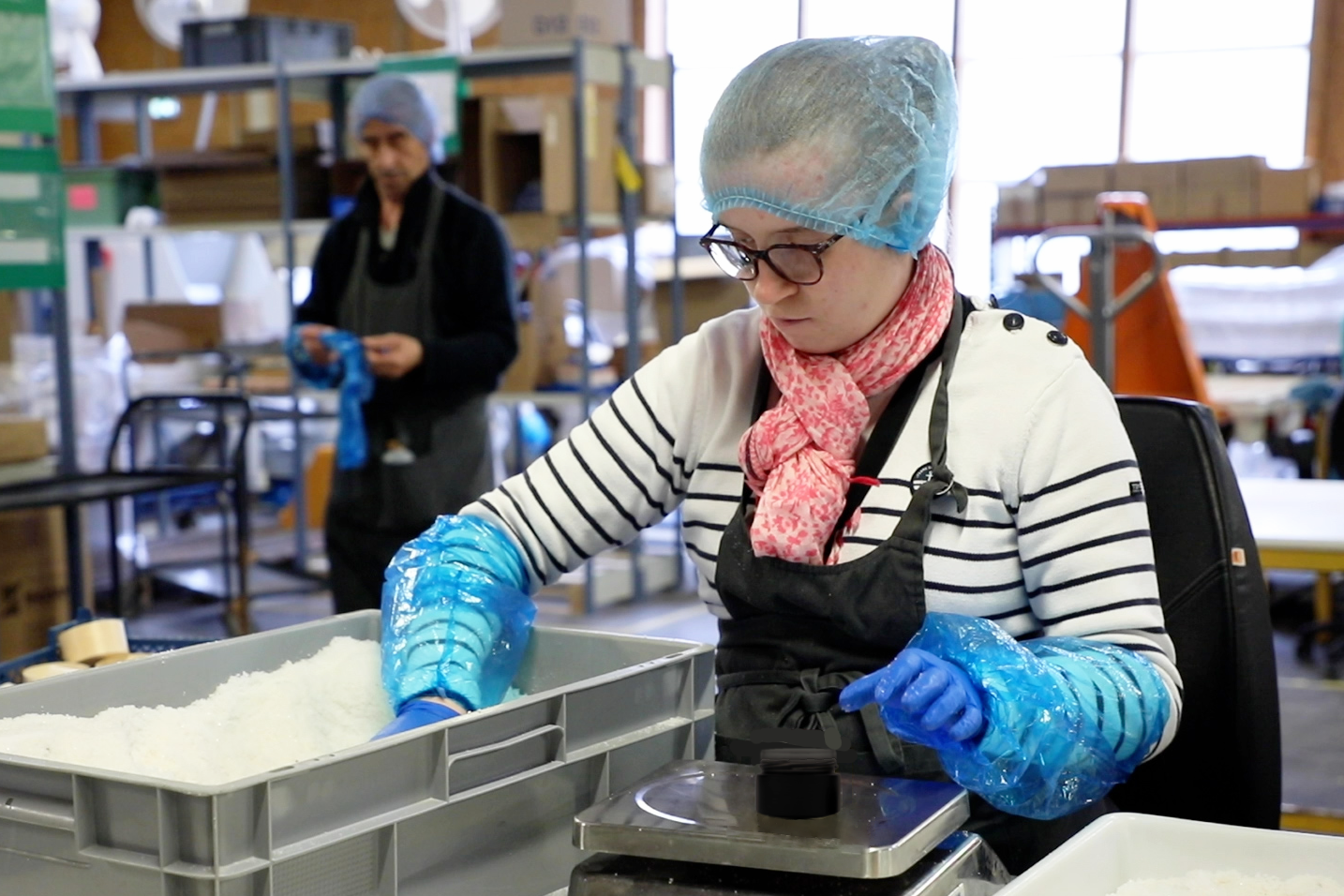 Travailleur d'ESAT en train de conditionner de la fleur de sel de Guérande de le pot de fleur de sel de Guérande "Entre Sel & Mer" au sein de l'ESAT le Tremplin de l'Atlantique, (VYV3 Pays de la Loire - Saint Nazaire / Guérande)
